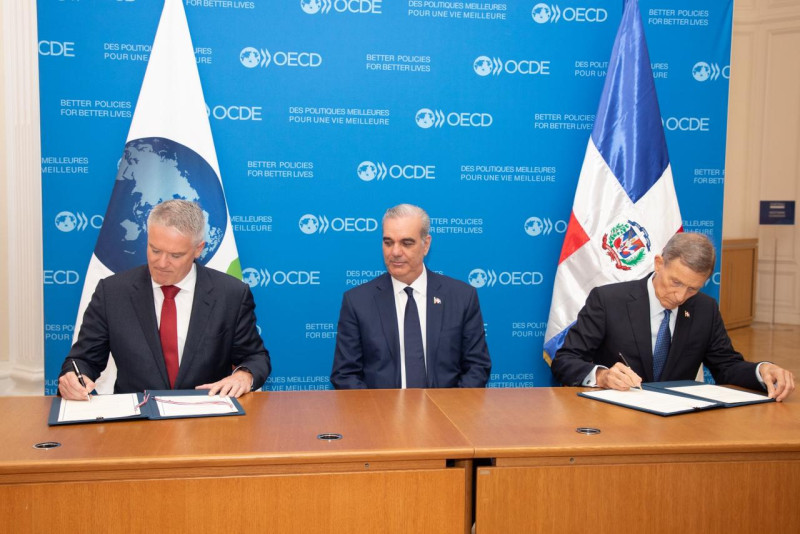 El secretario general de la OCDE, Mathias Cormann, y el canciller Roberto Álvarez, firman Memorando en presencia del presidente Luis Abinader.