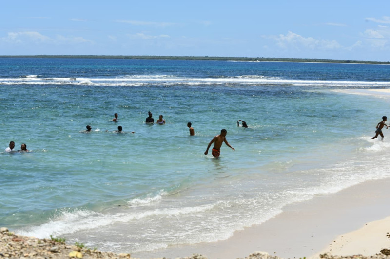 Dominicanos y extranjeros visitan la playa Caleta, pese alertas de vaguada en La Romana.