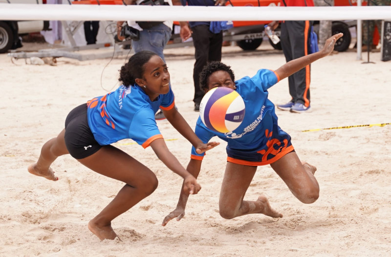 Dos jugadores se lanzan para tratar de salvar el balón en uno de los partidos de voleibol de playa escenificado en la arena de Boca Chica.