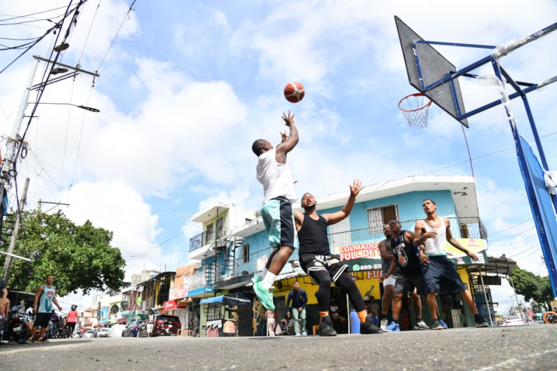 En Villa Agrícolas, un grupo de jóvenes juega un torneo amistoso de baloncesto, una actividad que repiten cada Viernes Santo desde hace seis años.
