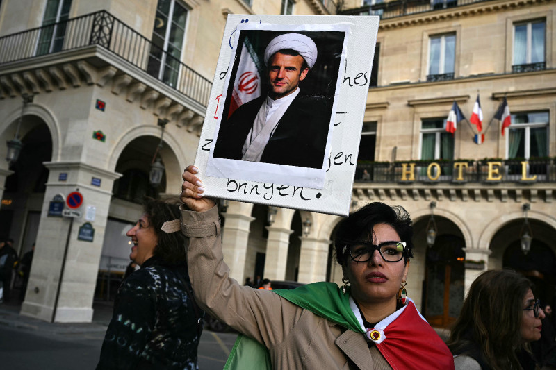Un manifestante sostiene un retrato del presidente francés Emmanuel Macron representado como un mulá durante una marcha contra la República Islámica de Irán en París el 5 de abril de 2026
