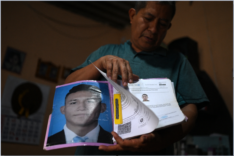 Reynaldo Santos, de 58 años, padre de Jonathan Santos, quien estuvo detenido y ahora se encuentra bajo el estado de excepción, muestra una fotografía y un certificado que prueba que su hijo no tiene antecedentes penales durante una entrevista con la AFP en su domicilio en Soyapango,