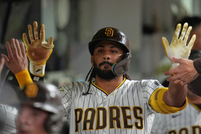 Fernando Tatis Jr. es recibido por sus compañeros luego de anotar una carrera.
