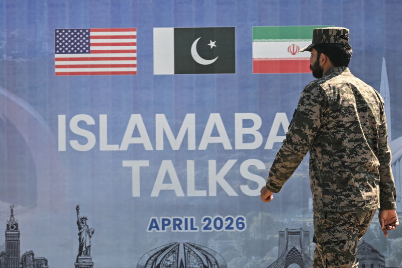 Un ranger pakistaní pasa junto a una valla publicitaria de las conversaciones de paz entre Estados Unidos e Irán en Islamabad el 12 de abril de 2026. Irán y Estados Unidos no lograron llegar a un acuerdo para poner fin a la guerra en Oriente Medio.