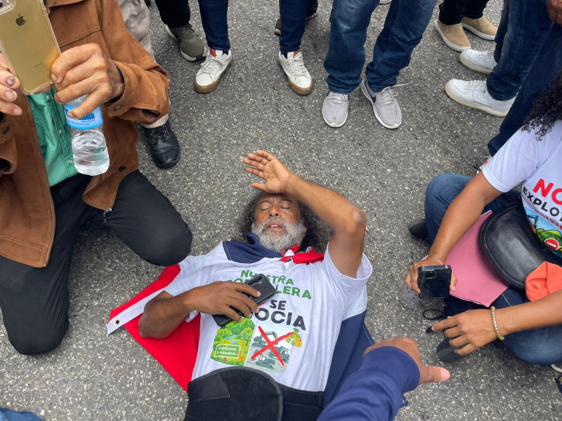 El padre Nino Ramos se acuesta a descansar en la autopista Duarte, después de recorrer varios kilómetros en lucha por proteger la Cordillera Septentrional de las empresas mineras.