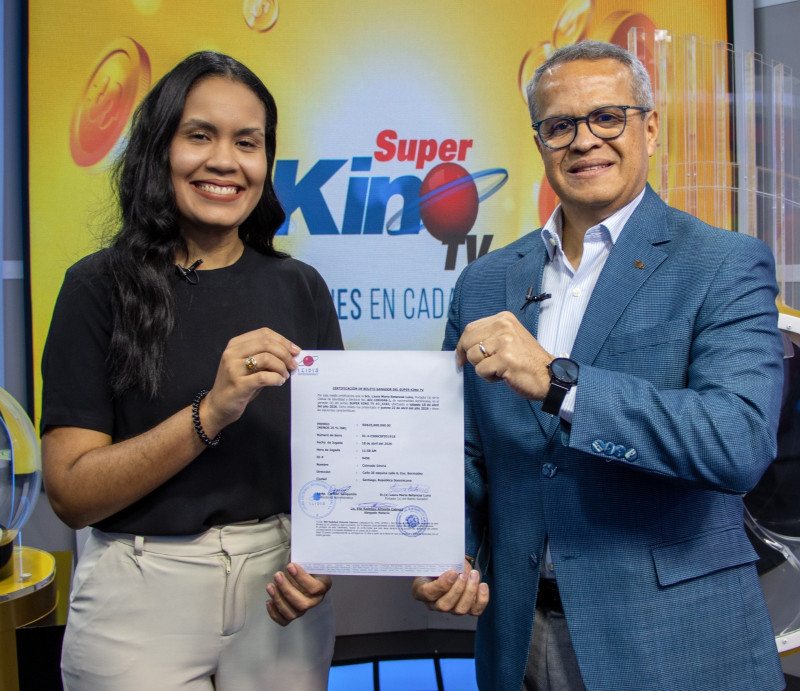 Laura María Betances recibe el certificado que la convierte en nueva millonaria.