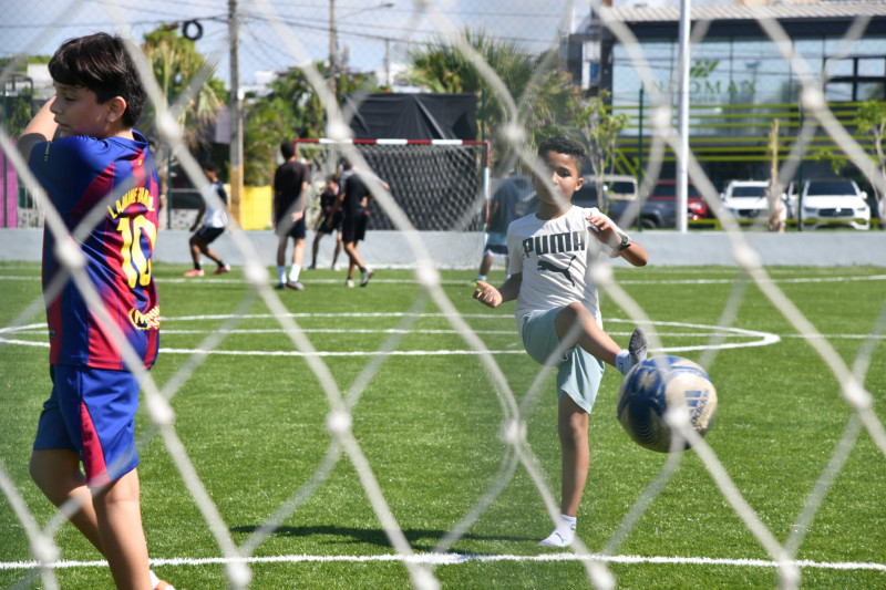 Niños jjugando al futbol bajo el sol, en las nuevas canchas del Malecón Deportivo