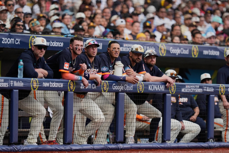 Manny Machado y varios compañeros observan desde el dogout la octava entrada el partido ante Arizona.