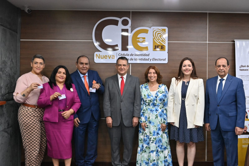 Miguel Franjul y su esposa, Wendy Santana, mientras renueva su cédula en la JCE, en compañía del presidente, Román Jáquez, y otras personalidades.