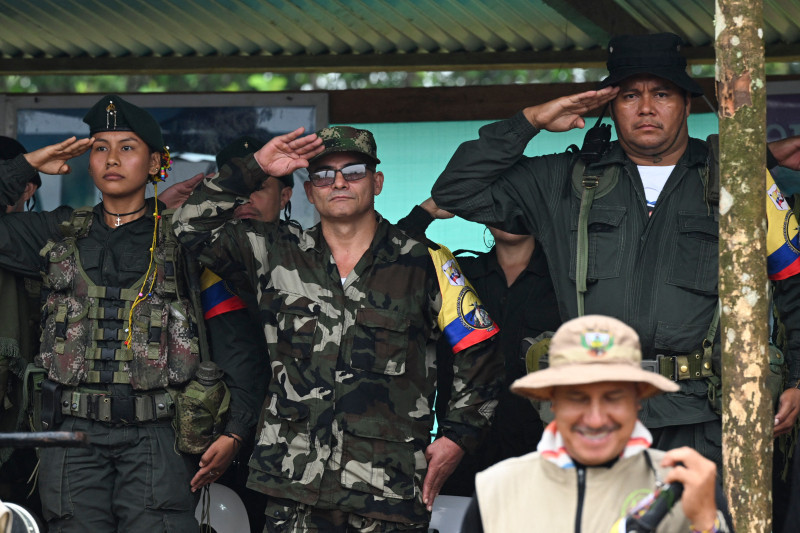 El máximo comandante de la disidencia del EP, alias Iván Mordisco (C), saluda militarmente junto al comandante Calarca (D) durante una reunión con comunidades locales en San Vicente del Caguan, departamento de Caquetá, Colombia, el 16 de abril de 2023.