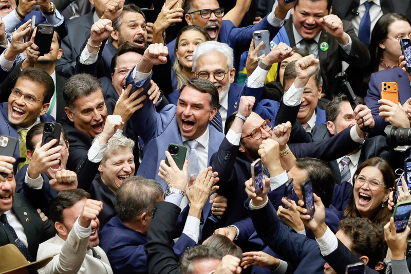 El senador Flavio Bolsonaro (C) celebra durante una sesión del Congreso Nacional que anuló el veto del presidente Lula a un proyecto de ley que reducía las penas para los condenados por el intento de golpe de Estado.