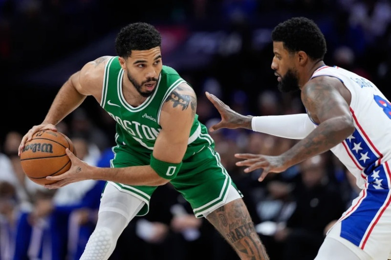 Jayson Tatum intenta superar la defensa de Paul George.
