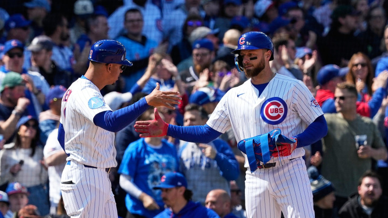 Michael Busch ancla en tercera luego de pegar triple con las bases llenas.