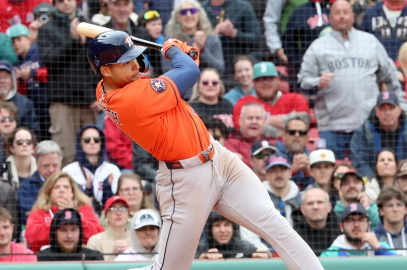 Cam Smith, de los Astros de Houston, conecta un sencillo permitiendo que dos corredores anoten durante la décima entrada de un partido de béisbol contra los Medias Rojas de Boston.