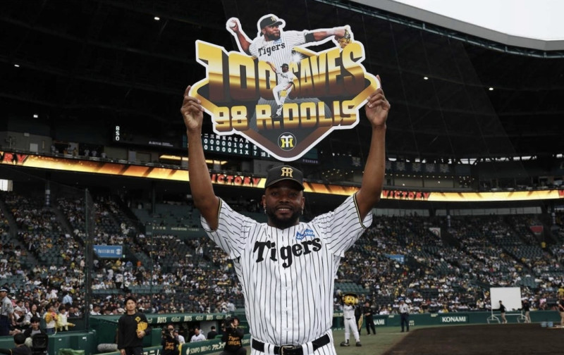 Rafael Dolis muestra un cartel relacionado con su logro de 100 salvados en la NPB.