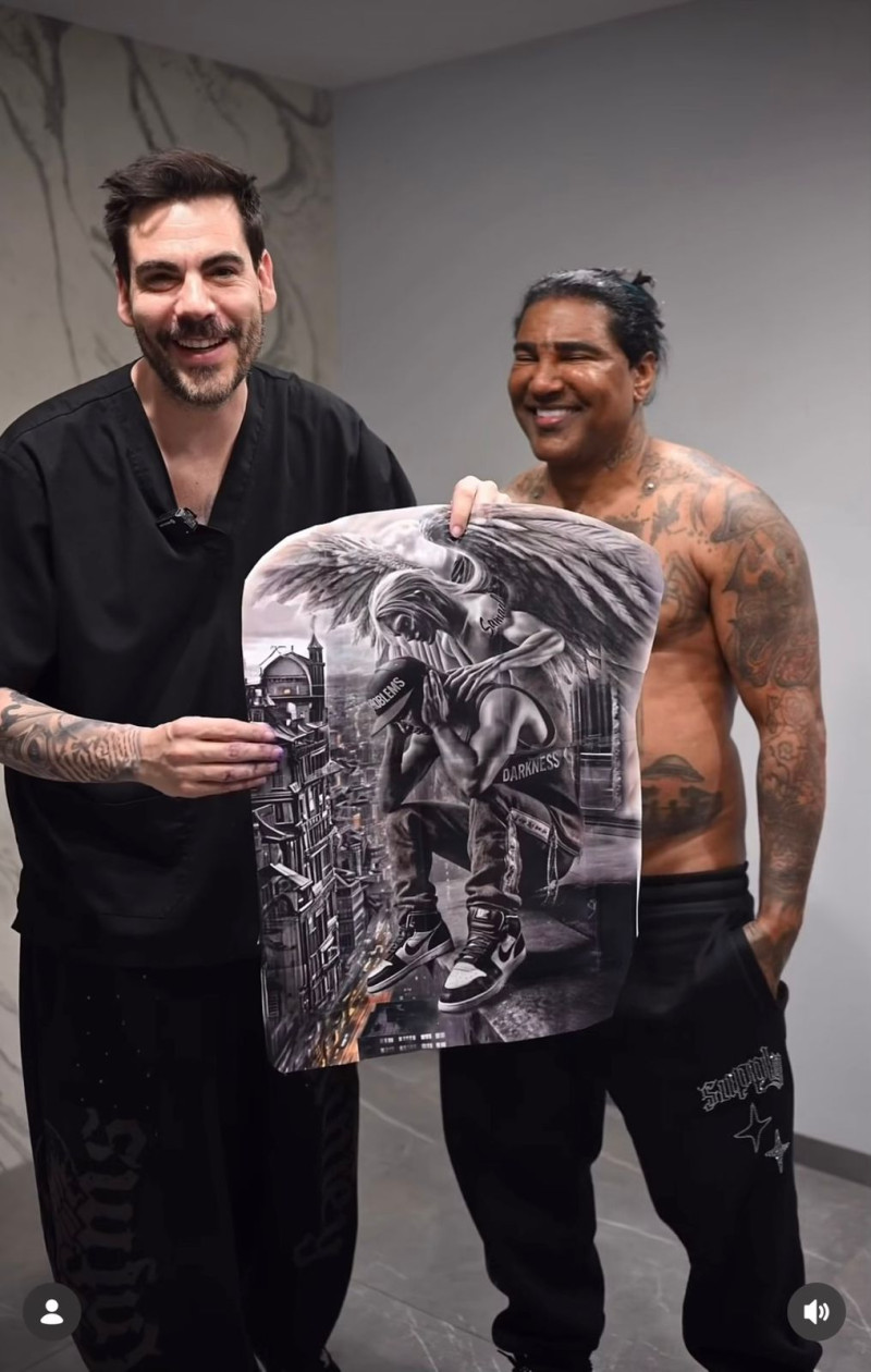 El artista Omega El Fuerte junto al tatuador español Miguel Bohigues.