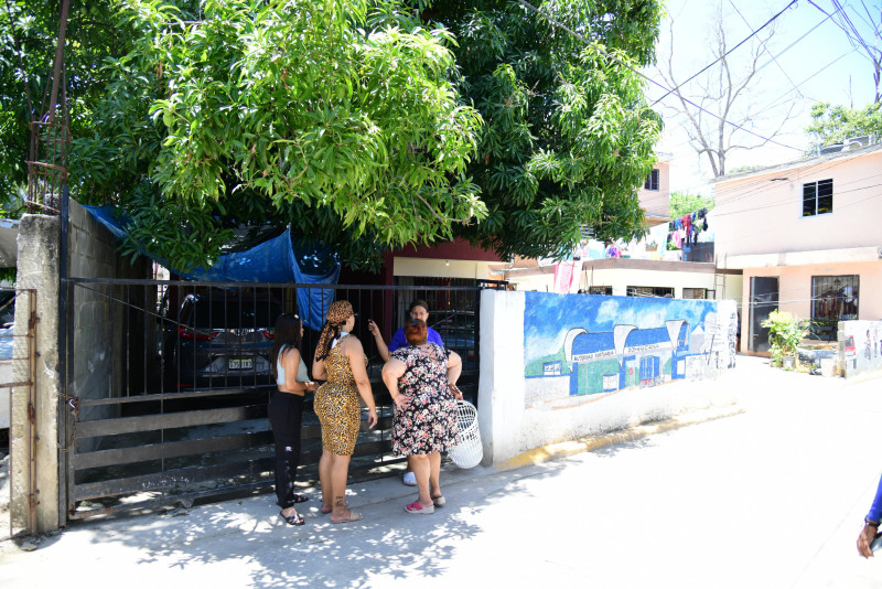 Vecinas se asoman a la casa de mujer ultimada a tiros por su pareja en el sector Barrio Nuevo, en el kilómetro 13 de la carretera Sánchez, Santo Domingo Oeste.