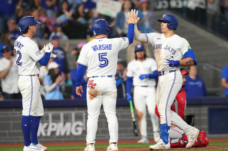 Brandon Valenzuela, de Toronto, es felicitado por sus compañeros luego de conectar un jonrón en el juego contra Anaheim.