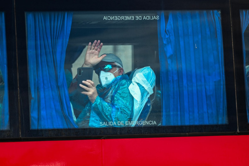 Un pasajero del crucero MV Hondius, saluda a bordo de un autobús militar tras ser trasladado en barco al puerto industrial de Granadilla de Abona, en la isla de Tenerife (Islas Canarias, España).