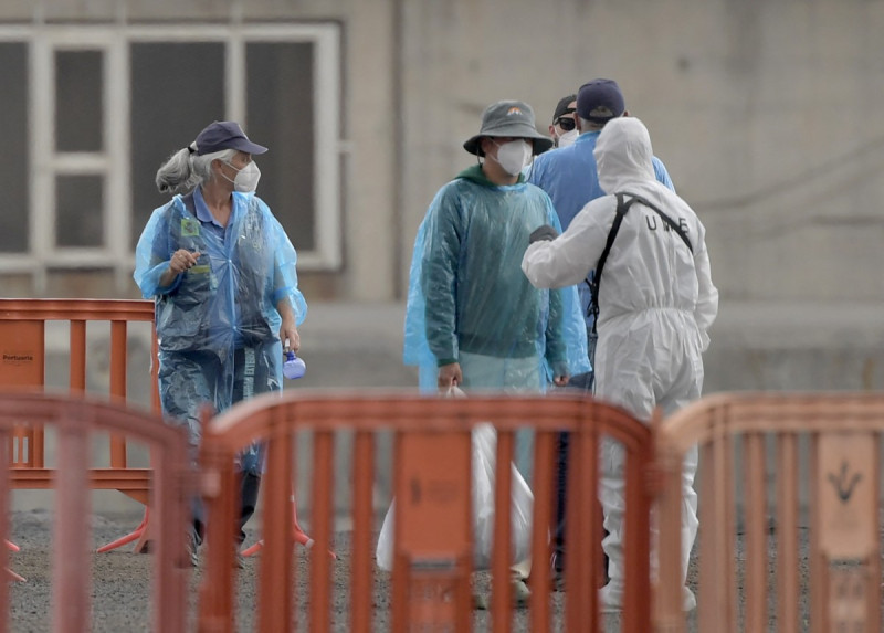 Pasajeros del crucero MV Hondius conversan con personal con trajes de protección biológica al desembarcar en el puerto industrial de Granadilla de Abona, en la isla de Tenerife (Islas Canarias, España), el 10 de mayo de 2026.