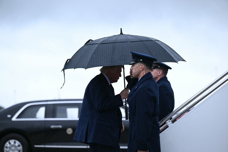 El presidente estadounidense Donald Trump sostiene un paraguas al abordar el Air Force One en la Base Conjunta Andrews en Maryland, el 22 de mayo de 2026.