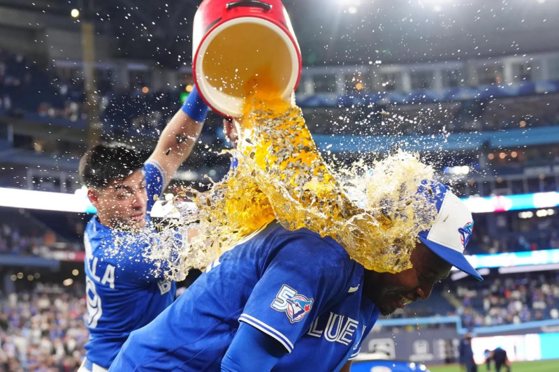 El dominicano Jesús Sánchez es bañado por su compañero Brandon Valenzuela luego que los Azulejos se impusieran 8 vueltas por 1 a los Marlins.