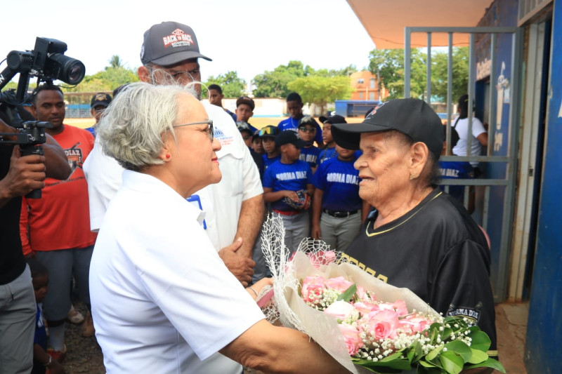 Empleados de la Dirección del Comisionado de Béisbol entregan un ramo de flores a Doña Norma Díaz por el Día de las Madres.