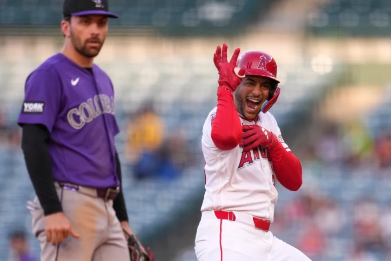 José Siri, de los Angelinos, festeja luego de batear un doble productor, detrás de Edouard Julien, de los Rockies, el 3 de junio de 2026.