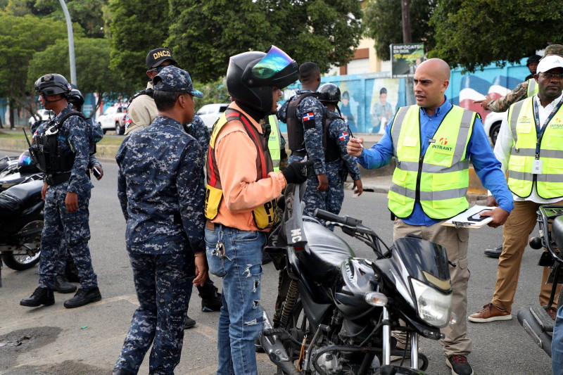 Autoridades revisan documento de un motoconchista durante operativo de fiscalización de paradas.