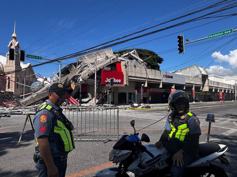 Policías se reúnen frente a un restaurante de comida rápida Jollibee derrumbado tras un terremoto de magnitud 7.8 en la ciudad de General Santos el 8 de junio de 2026. Un terremoto de magnitud 7.8 que sacudió el sur de Filipinas el 8 de junio causó la muerte de al menos una persona y el derrumbe de edificios, según informó la policía, mientras que el desastre provocó alertas de tsunami en toda la región.