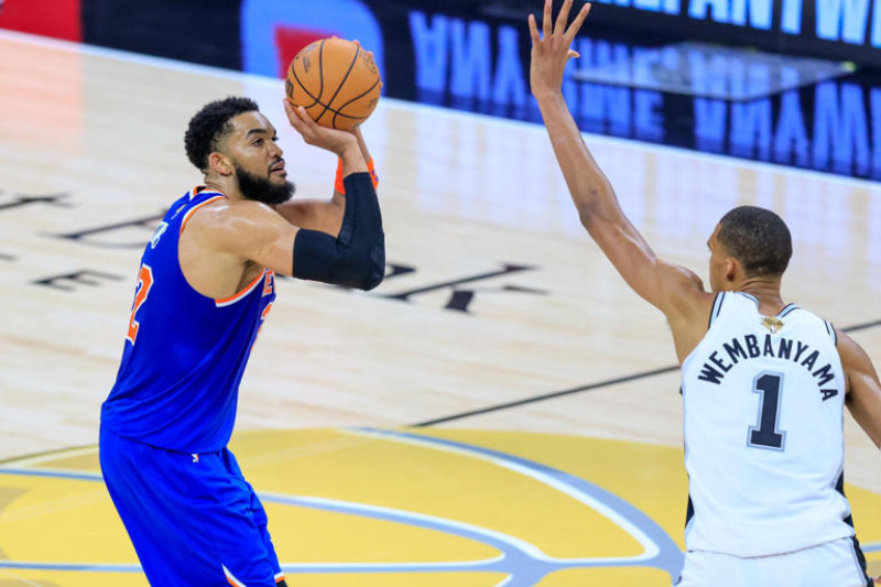 Karl-Anthony Towns, de los Knicks, intenta realiza un lance al canasto frente a Victor Wembanyama, de los Spurs, en acción de la final de la NBA.