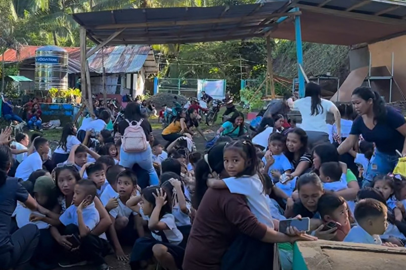 Esta captura de pantalla, tomada de un video generado por usuarios y cortesía de la Escuela Primaria Mahayahay del Departamento de Educación, muestra a escolares reunidos en un campo reaccionando durante el terremoto en la ciudad de Malita