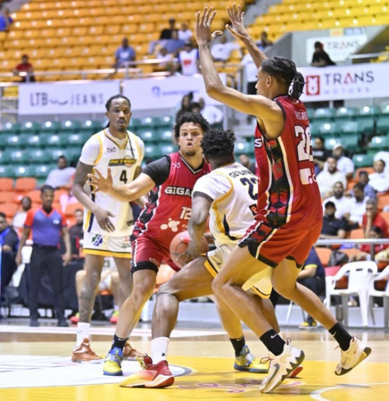 Dos defensores de Gigantes rodean a jugador de Metros.