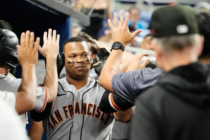 Rafael Devers, de los Gigantes, es felicitado en el dugout tras pegar un jonrón contra los Marlins, el 19 de junio del 2026, en Miami.