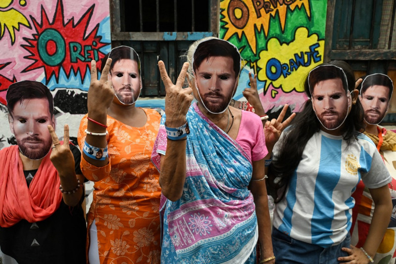 Mujeres con máscaras del futbolista argentino Lionel Messi posan para una fotografía mientras celebran su cumpleaños en Calcuta el 24 de junio de 2026.