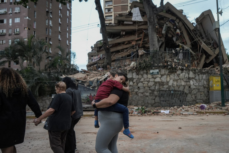 Unas personas pasan junto a un edificio derrumbado tras un terremoto en Caracas el 25 de junio de 2026.