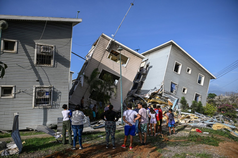 Personas permanecen frente a viviendas dañadas tras un terremoto en Catia La Mar, estado de La Guaira —a unos 30 km al noroeste de Caracas—, el 25 de junio de 2026.