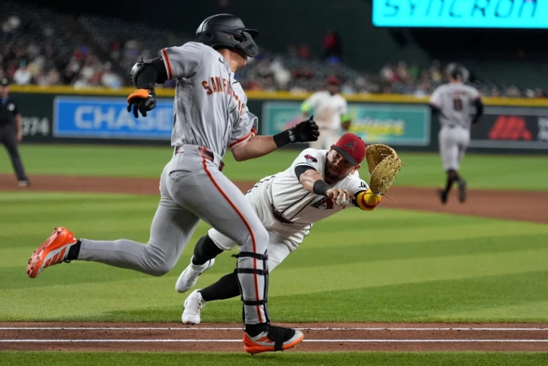 El inicialista de los Diamondbacks, Ildemaro Vargas, se lanza para tocar a Jung Hoo Lee, de los Gigantes durante el juego de Grandes Ligas, el 29 de junio del 2026.
