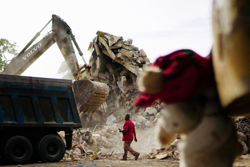 Un hombre pasa junto a una retroexcavadora que retira escombros para iniciar las labores de demolición en el lugar de un edificio colapsado en el sector de Tanaguarena, en Caraballeda (estado de La Guaira, Venezuela), el 3 de julio de 2026.
