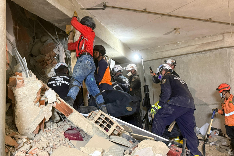 Esta imagen, distribuida por el Departamento de Bomberos y Rescate de Miami, muestra a los rescatistas trabajando para sacar a Hernán Gil, quien sobrevivió durante casi ocho días bajo los escombros.