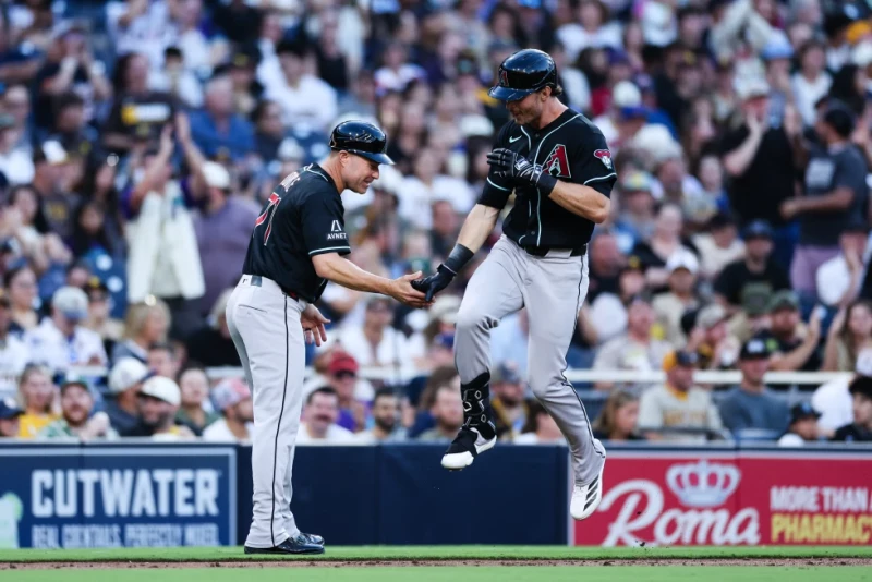 Max Kepler, de los Diamondbacks, es felicitado por el coach de tercera base, J.R. House, después de disparar un jonrón de tres carreras ante los Padres, el 6 de julio de 2026.