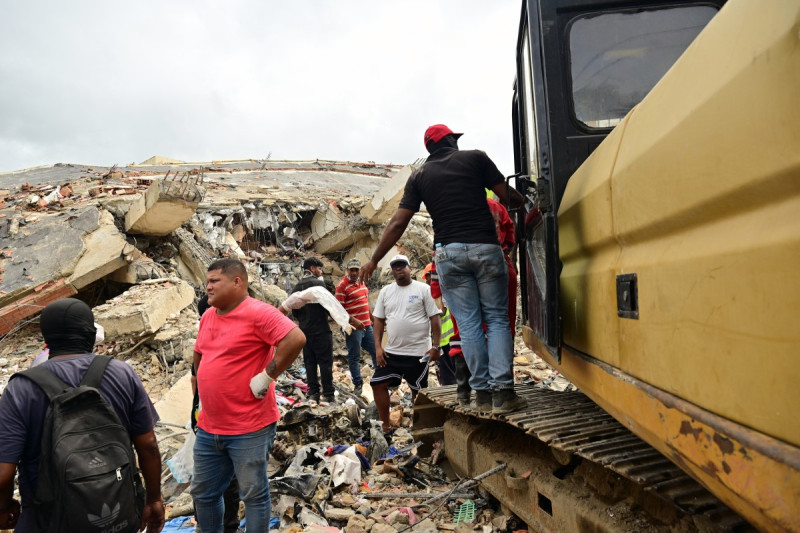 Trabajadores y residentes retiran escombros en el lugar de un edificio colapsado en Caraballeda, estado de La Guaira.