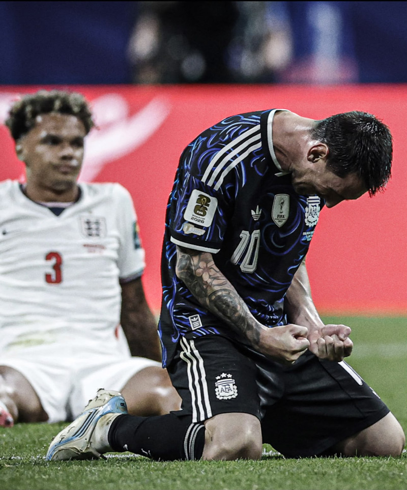 El astro argentino celebra el triunfo mientras es observado por Nico O'Reilly, de la selección inglesa.