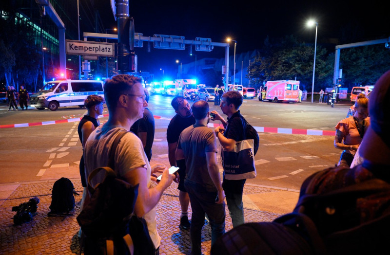 Personal de emergencia y agentes de policía trabajan cerca del lugar donde una persona murió y unas 15 resultaron heridas después de que, al parecer, un automóvil atropellara a una multitud.