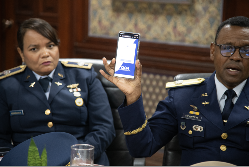 Juan C. Vicente Pérez, director de Inteligencia Migratoria, muestra herramienta tecnológica que utilizan. Observa Jael Rodríguez R.