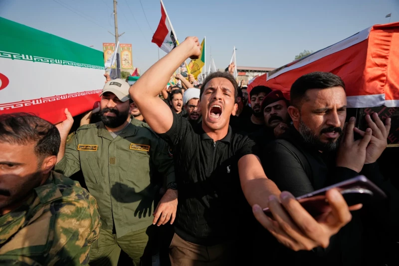Dolientes portan ataúdes con la bandera iraní y la bandera iraquí durante un funeral colectivo por asesores iraníes y combatientes de las Fuerzas de Movilización Popular (FMP), muertos en ataques aéreos contra bases de las FMP.