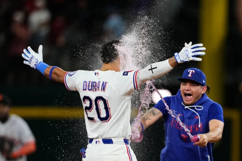 Ezequiel Durán, de los Rangers, es empapado por Alejandro Osuna, tras el triunfo sobre los Gigantes en el juego del 4 de agosto de 2026.