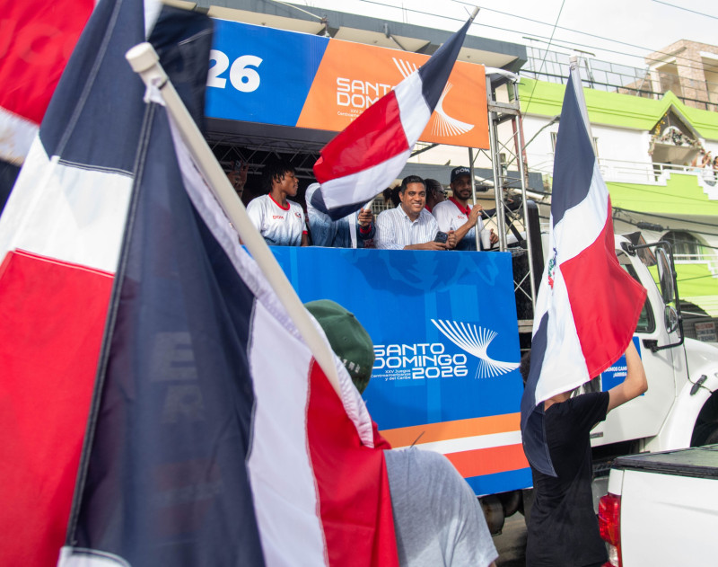 Kelvin Cruz y Marileidy Paulino participan en la marcha mientras son rodeados por banderas de República Dominicana.