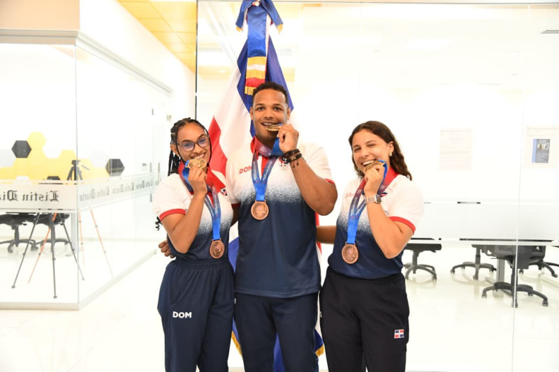 Los judocas Ana Rosa, Robert Florentino y Esmeralda Damiamo posan con su medalla de oro durante su visita al Listín Diario.