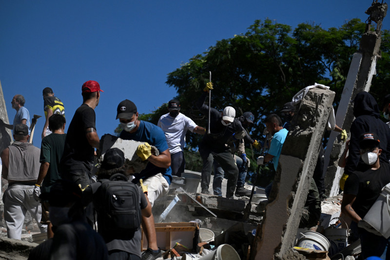 Personas y rescatistas buscan sobrevivientes entre los escombros de un edificio derrumbado tras un terremoto en Cali, Colombia, el 10 de agosto de 2026.
